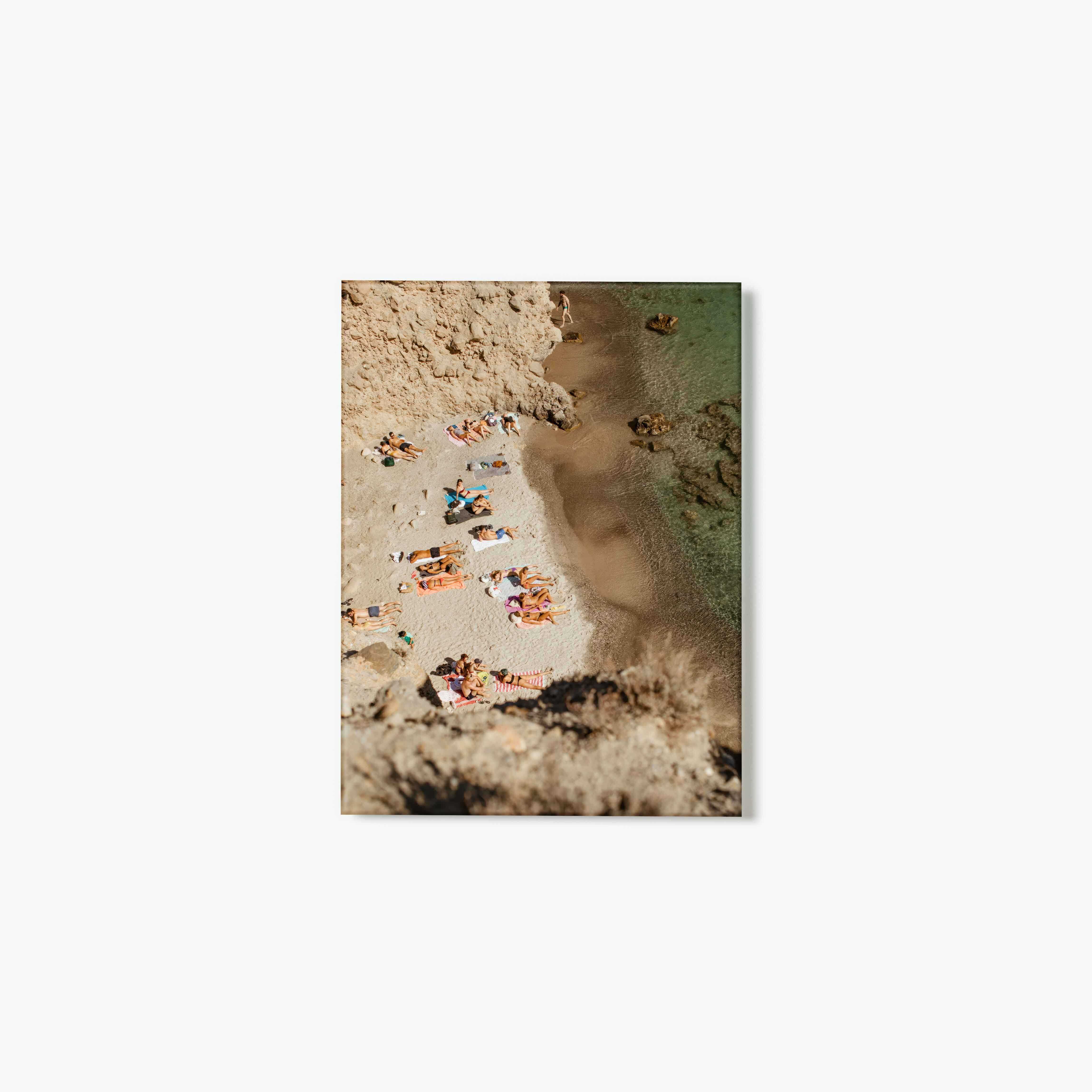 Aerial view of people on a beach with sand and water.